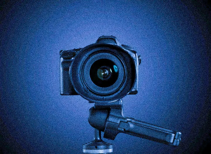 A camera mounted on a tripod facing forward